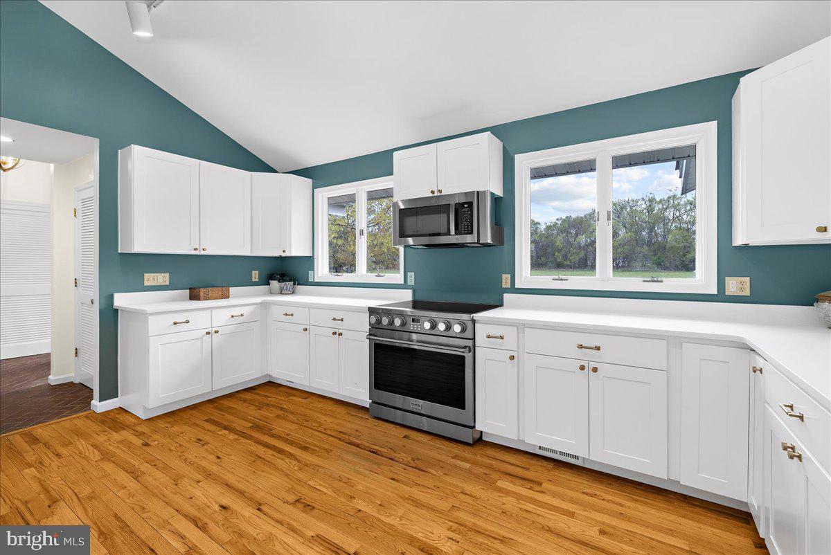 26889 Morgnec Road Chestertown, MD 21620 - Photo 8 of 32 a kitchen with stainless steel appliances granite countertop a stove a sink and white cabinets
