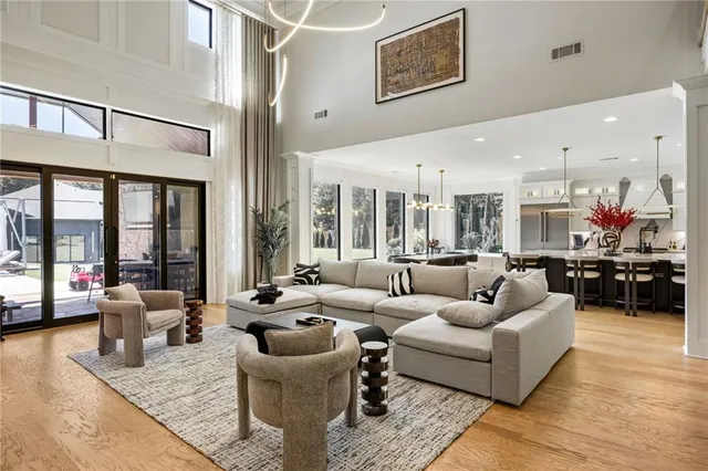a living room with furniture kitchen view and a chandelier