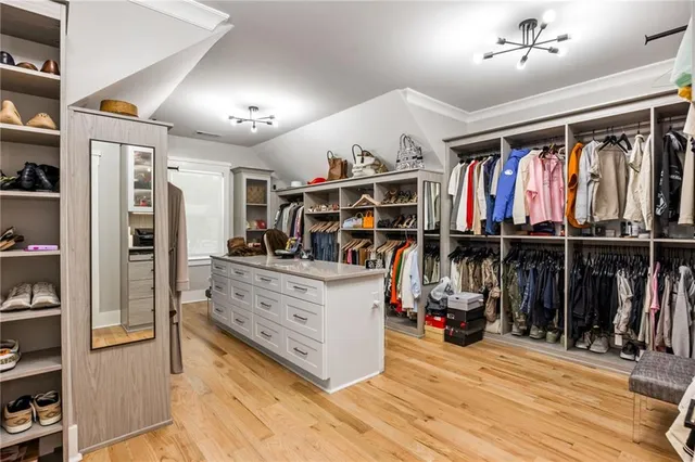 a spacious bedroom with a bed a flat screen tv and dresser