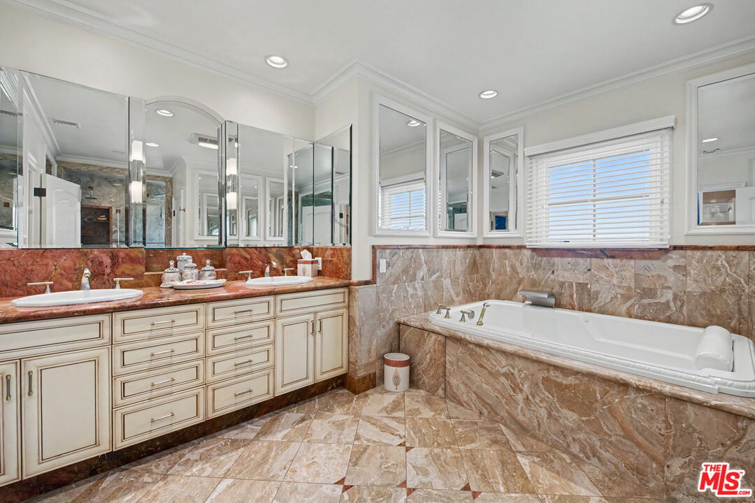204 Foothill Road Beverly Hills, CA 90210 - Photo 28 of 38 a bathroom with a tub sink and mirror