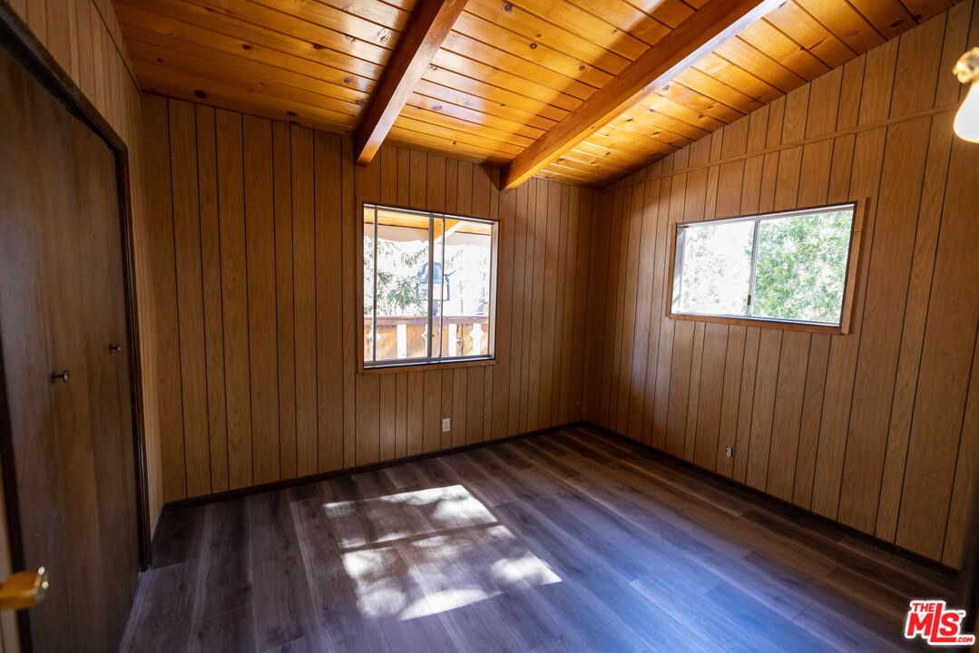 5212 Lone Pine Canyon Road Wrightwood, CA 92397 - Photo 12 of 42 a view of an empty room with wooden floor and a window