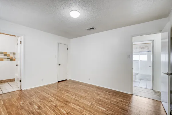 a view of a room with wooden floor and bathroom