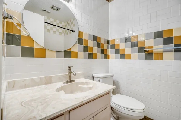 a bathroom with a sink a toilet and a mirror