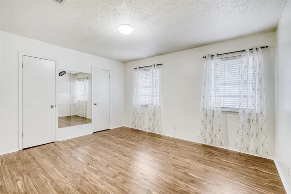a view of an empty room with cabinet and a window