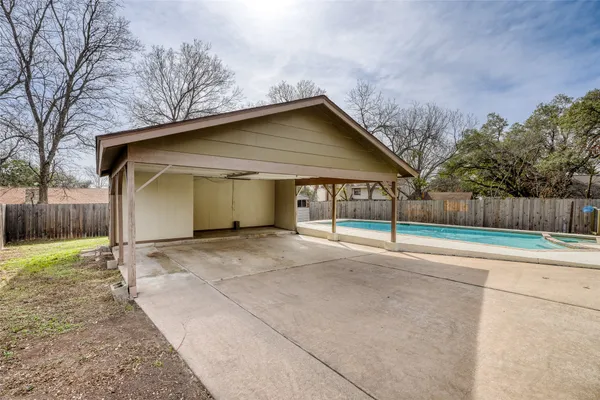 a view of a house with a yard and large tree