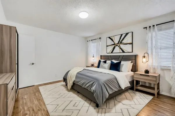 a bedroom with a bed and wooden floor