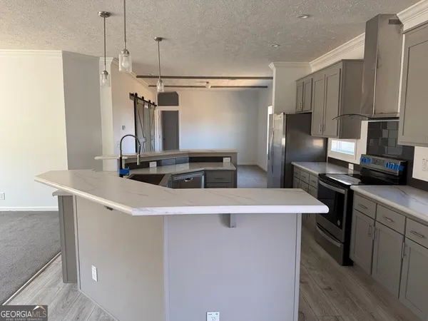 a kitchen with stainless steel appliances kitchen island a refrigerator sink and stove