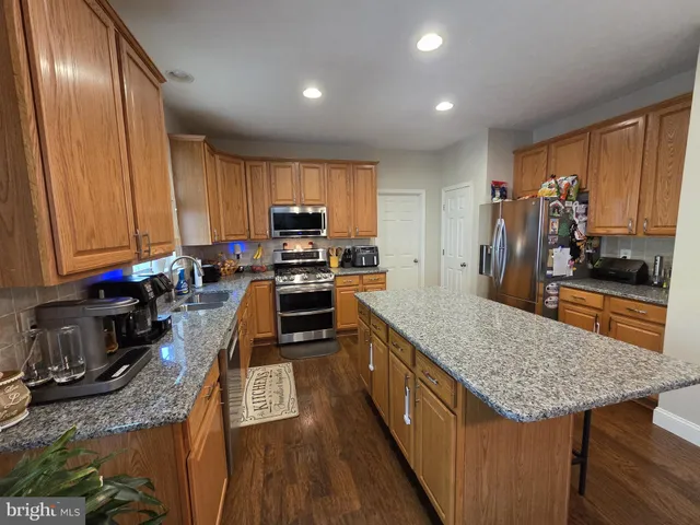 a kitchen with stainless steel appliances granite countertop a stove top oven a sink and dishwasher