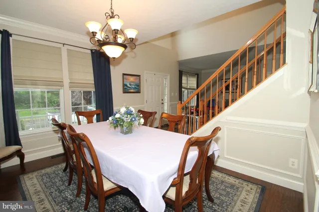 a view of a dining room with furniture a chandelier and wooden floor