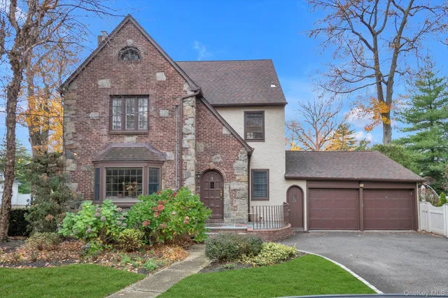 a front view of a house with a garden and plants
