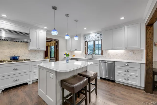 a kitchen with white cabinets and appliances