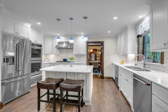 a kitchen with kitchen island a sink stove and refrigerator