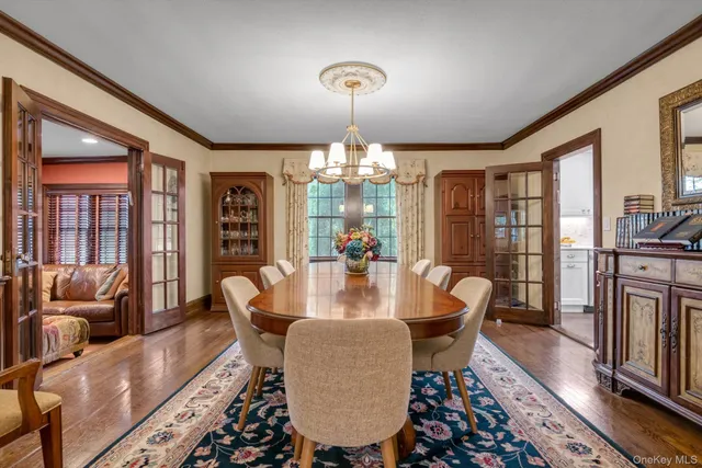 a dining room with furniture a chandelier and wooden floor