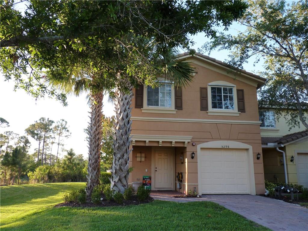 5298 Southeast Mitchell Lane Stuart, FL 34997 - Photo 1 of 33 a view of a white house with a large tree and a yard and a tree