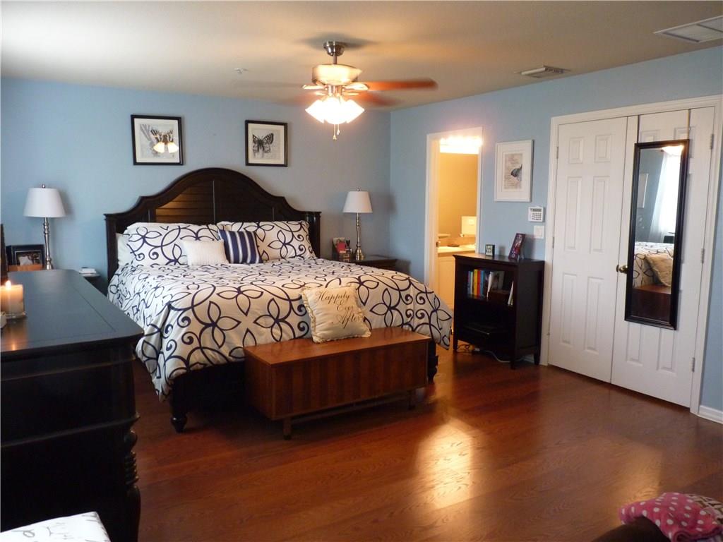 5298 Southeast Mitchell Lane Stuart, FL 34997 - Photo 11 of 33 a bedroom with a bed and wooden floor