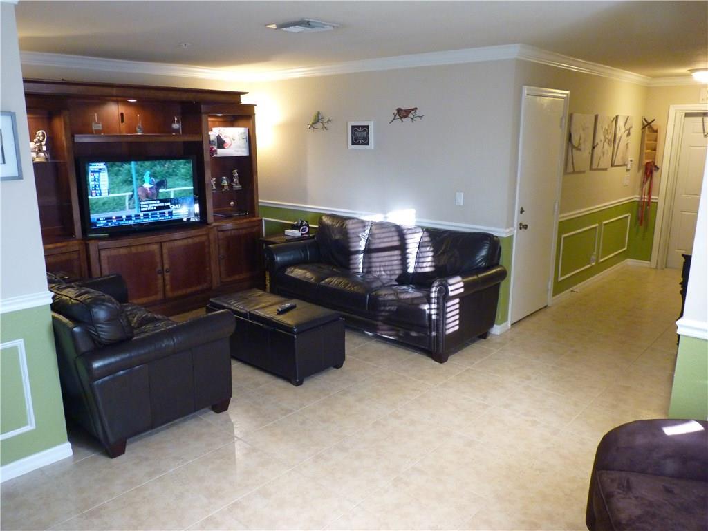 5298 Southeast Mitchell Lane Stuart, FL 34997 - Photo 2 of 33 a living room with furniture and a flat screen tv