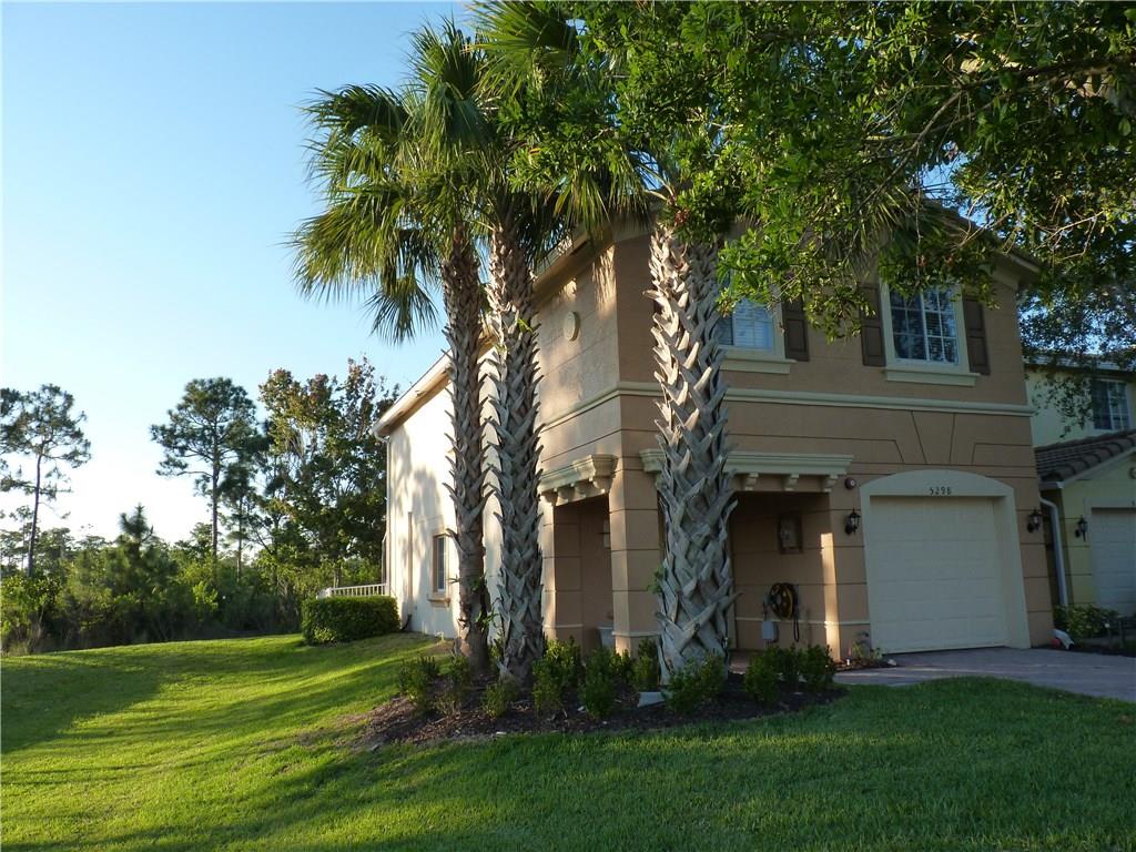 5298 Southeast Mitchell Lane Stuart, FL 34997 - Photo 32 of 33 a view of a white house next to a yard with palm trees