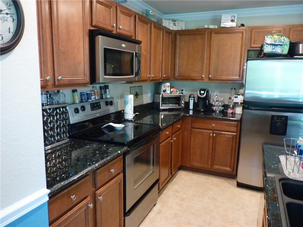 5298 Southeast Mitchell Lane Stuart, FL 34997 - Photo 7 of 33 a kitchen with stainless steel appliances granite countertop a sink stove and microwave