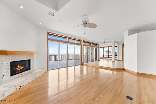 a view of an empty room with wooden floor and a fireplace