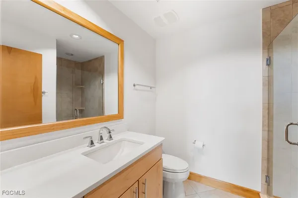 a bathroom with a granite countertop sink toilet and mirror