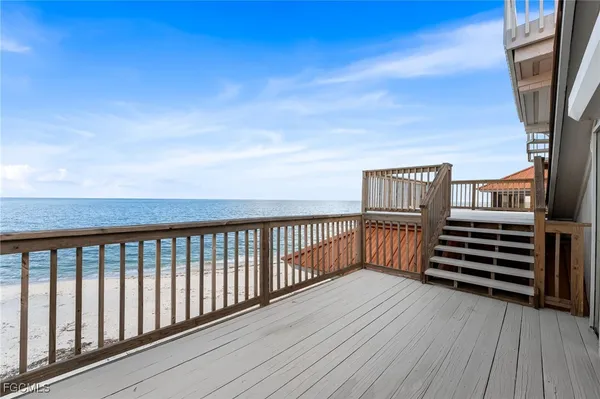 a view of a balcony with wooden floor and fence