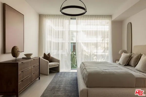 a bedroom with a bed and a large window