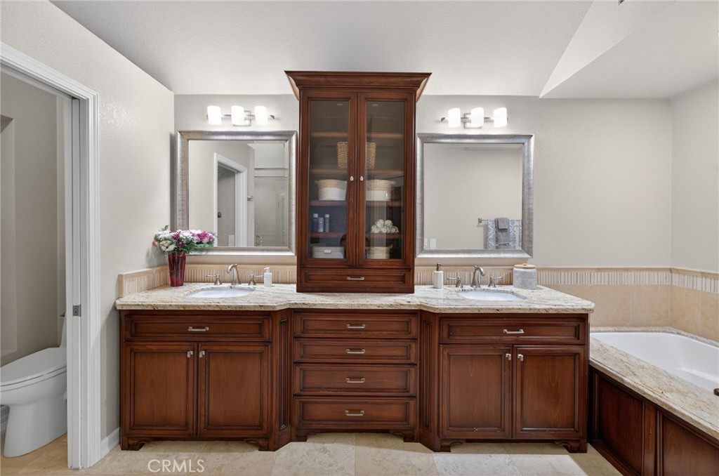964 South Rim Crest Drive Anaheim, CA 92807 - Photo 38 of 69 a spacious bathroom with a granite countertop sink and a mirror