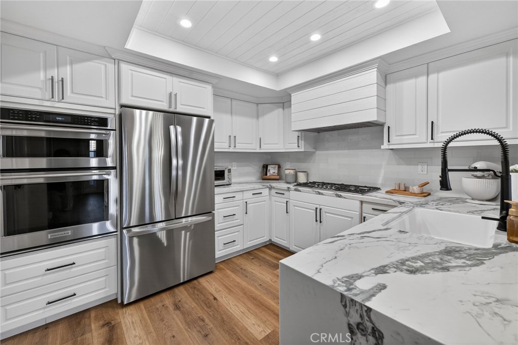 964 South Rim Crest Drive Anaheim, CA 92807 - Photo 5 of 69 a kitchen with granite countertop a refrigerator stove and white cabinets