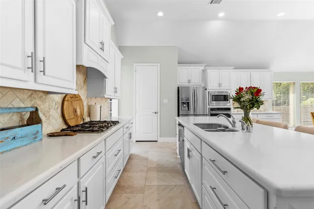 a kitchen with kitchen island granite countertop a sink stove and cabinets