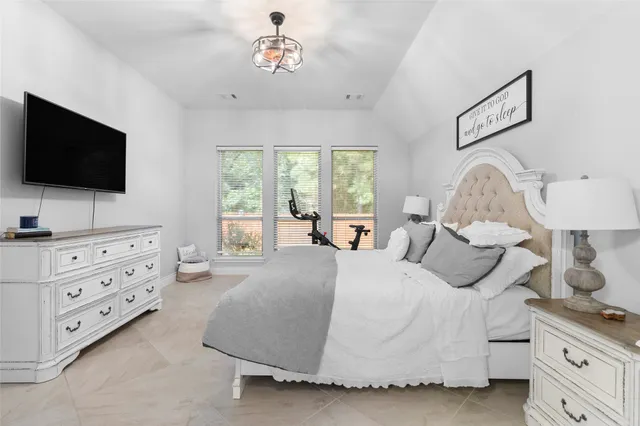 a spacious bedroom with a bed and a flat screen tv