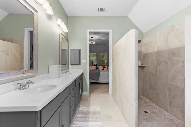 a en suite bathroom with a double vanity sink a mirror and a shower
