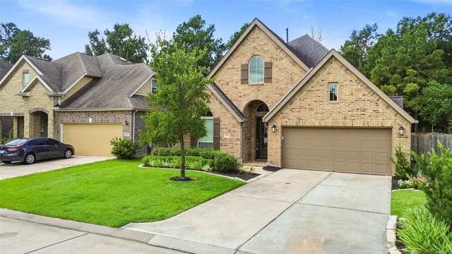 a front view of a house with a yard and trees