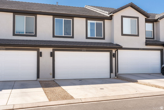1693 Devils Gdn Lane Washington, UT 84780 - Photo 37 of 64 Townhome exterior featuring light-colored stucco siding with dark trim accents