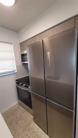 a kitchen with metallic refrigerator and white stainless steel appliances