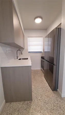 a kitchen with stainless steel appliances granite countertop a refrigerator and a sink