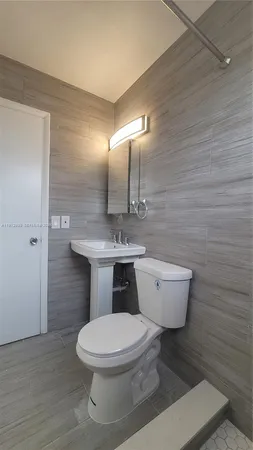 a white toilet sitting next to a bathroom sink
