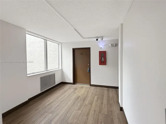 a view of a big room with wooden floor and windows