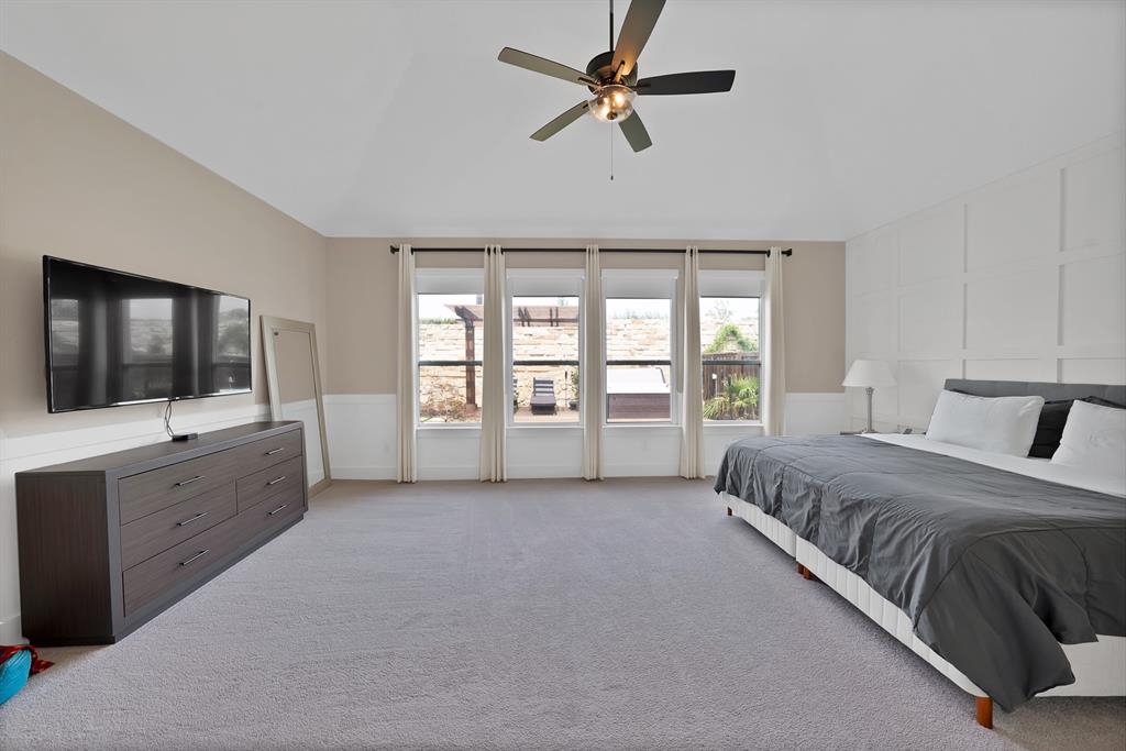 1010 Adair Road Prosper, TX 75078 - Photo 13 of 39 a spacious bedroom with a large bed and a flat screen tv