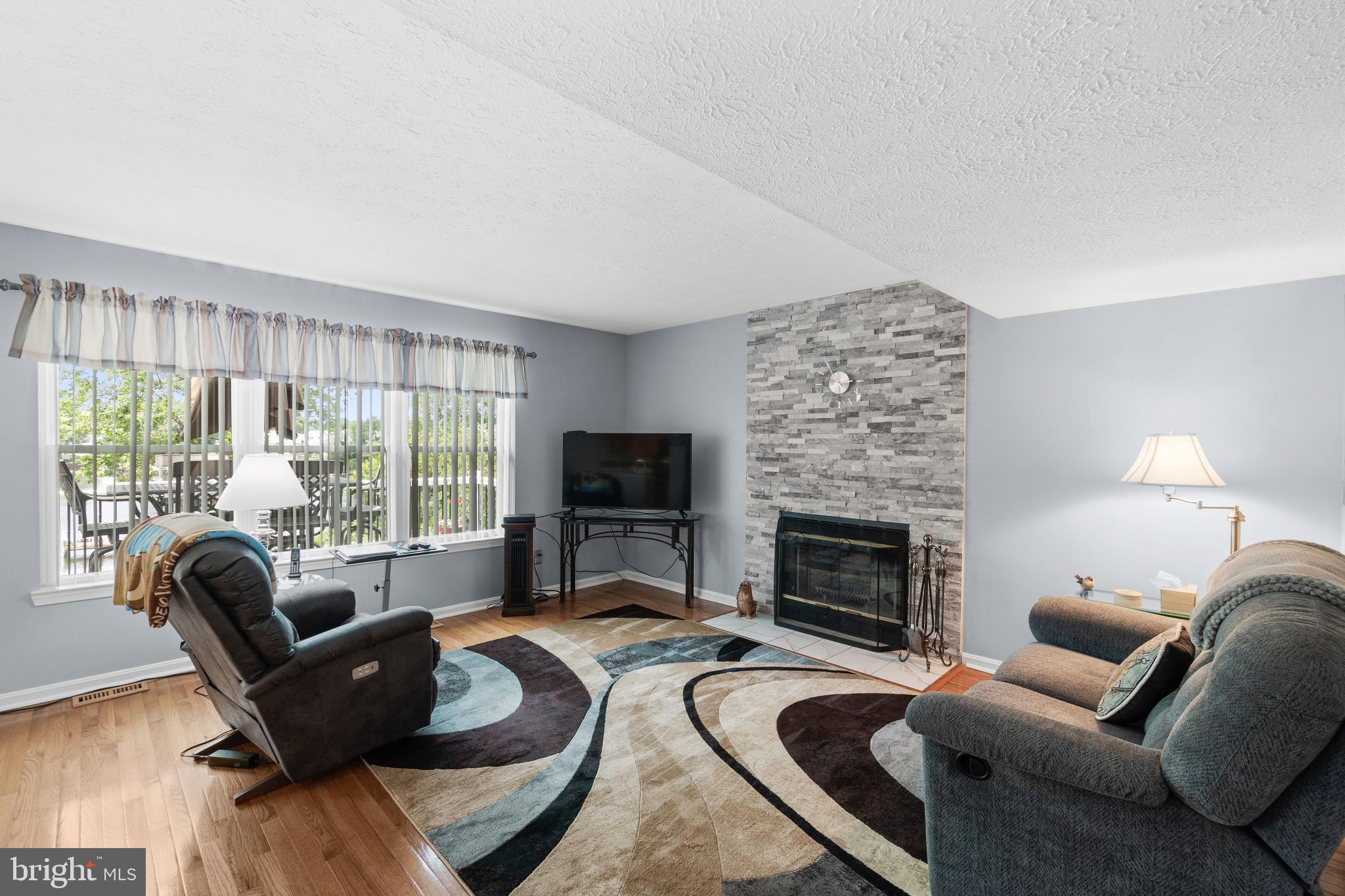 7708 West Shore Road Pasadena, MD 21122 - Photo 8 of 31 Stacked stone fireplace in family room with a view