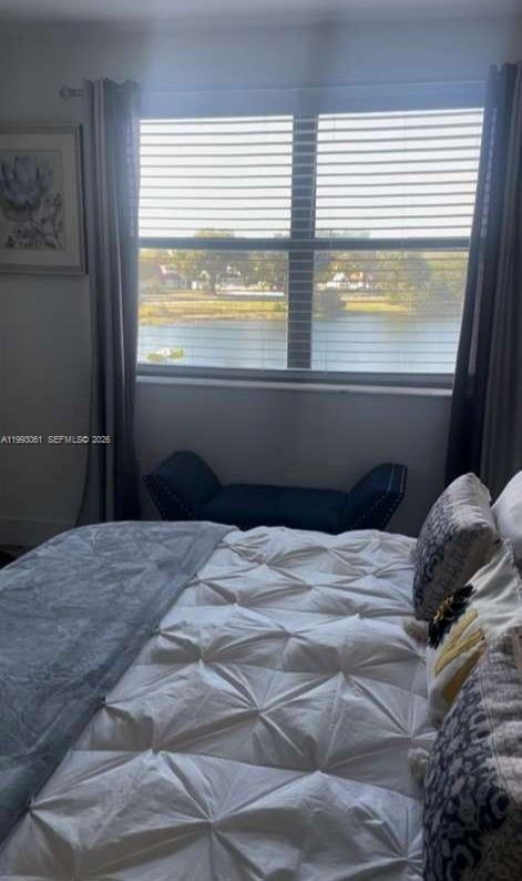 10000 Northwest 9th St Circle, Unit 11 Miami, FL 33172 - Photo 3 of 10 a bed sitting in a bedroom next to a window