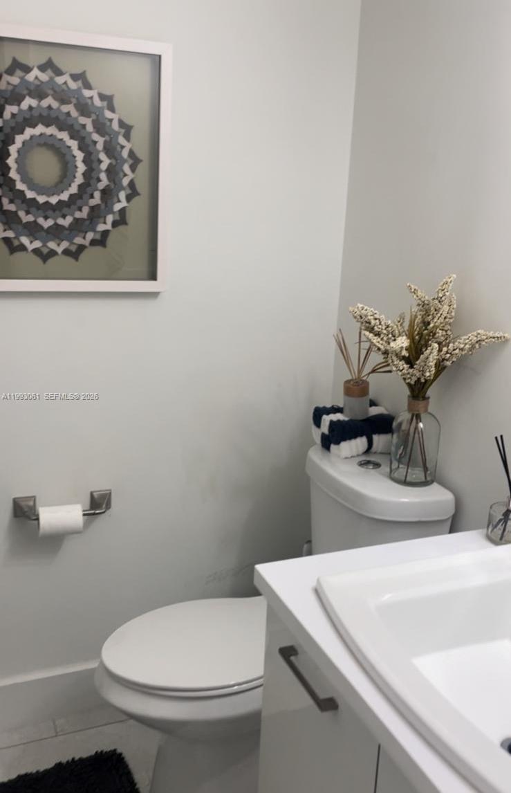 10000 Northwest 9th St Circle, Unit 11 Miami, FL 33172 - Photo 7 of 10 a bathroom with a toilet a sink and mirror