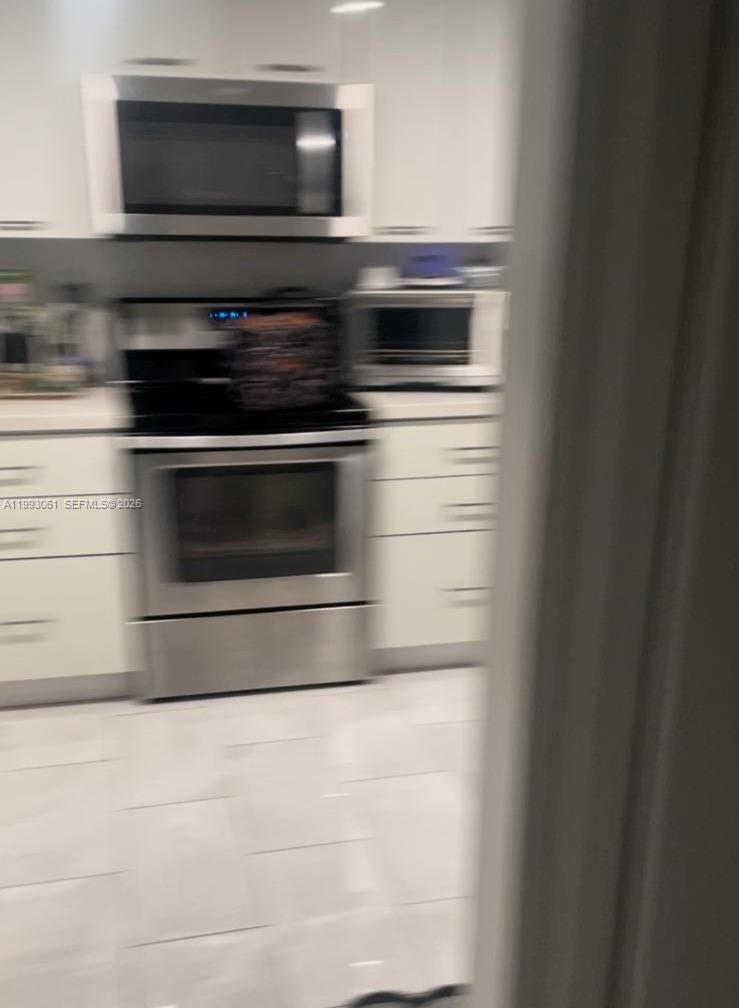 10000 Northwest 9th St Circle, Unit 11 Miami, FL 33172 - Photo 9 of 10 a stove top oven sitting inside of a kitchen