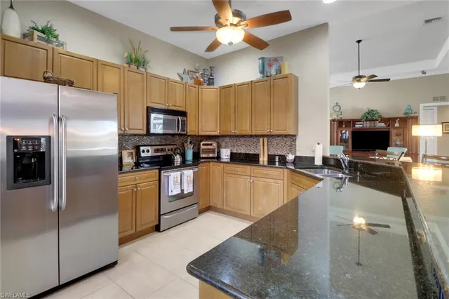 a kitchen with stainless steel appliances granite countertop a sink a stove and a refrigerator