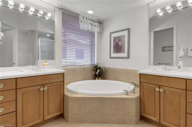 a bathroom with a tub a sink and mirror