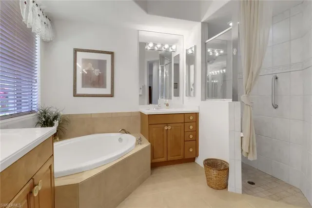 a bathroom with a tub a sink and mirror