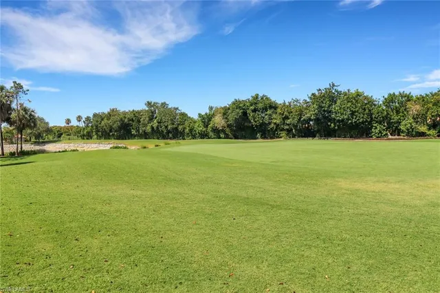 a view of yard with ocean and trees in the background