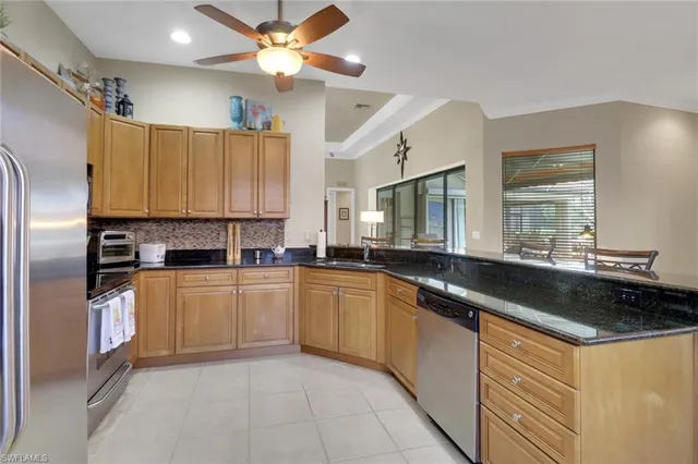 a kitchen with granite countertop a sink stainless steel appliances and cabinets