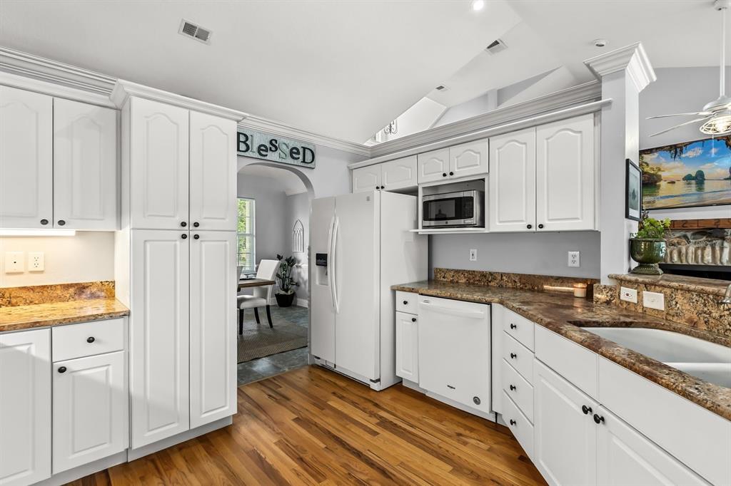 32530 Senese Road Sorrento, FL 32776 - Photo 14 of 34 a kitchen with granite countertop cabinets and steel stainless steel appliances