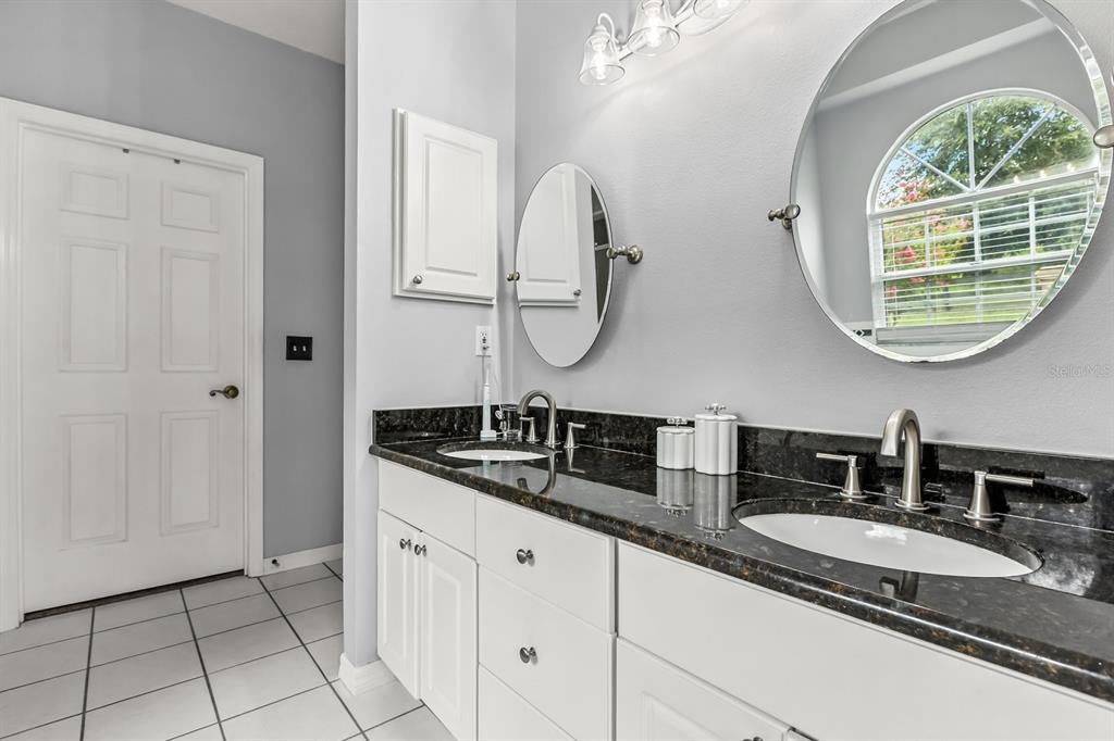 32530 Senese Road Sorrento, FL 32776 - Photo 21 of 34 a bathroom with a granite countertop sink and a mirror