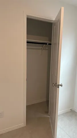 an empty room with closet and a bathroom